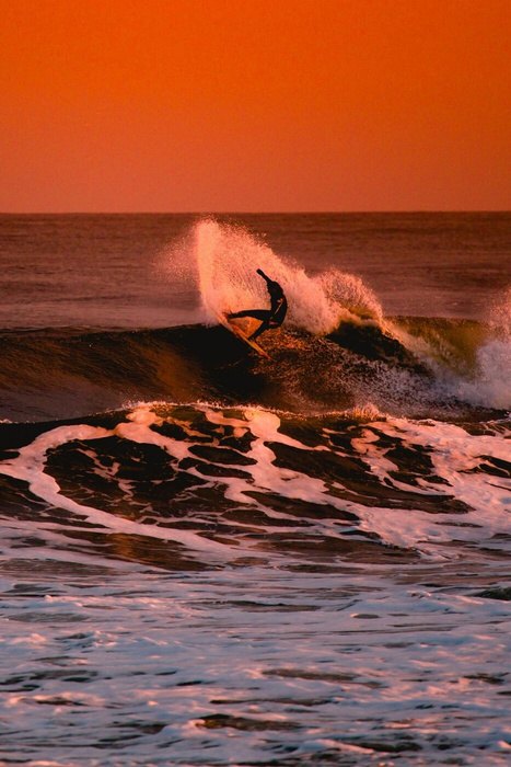 Surfer on a wave at sunset